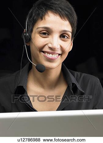 Businesswoman wearing headset, working on laptop. Brussels, Belgium. View Large Photo Image Stock Photo - Businesswoman wearing headset, working on laptop. Brussels, Belgium.. Fotosearch
