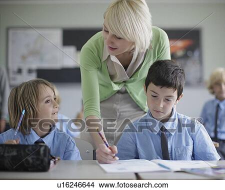 Picture - Female teacher correcting student work. Fotosearch