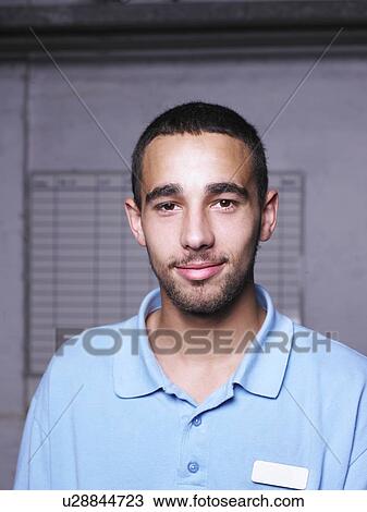 Stock Image - Garage worker standing in shop. Fotosearch