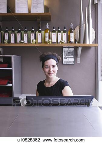 Stock Image - Hostess at her station in a restaurant. Fotosearch