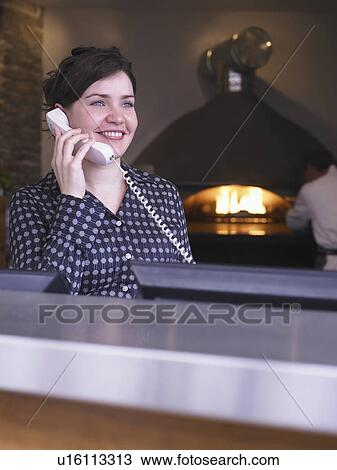 Hostess at her station in a restaurant View Large Photo Image Stock Image - Hostess at her station in a restaurant. Fotosearch