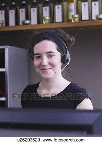 Stock Image - Hostess at her station in a restaurant. Fotosearch