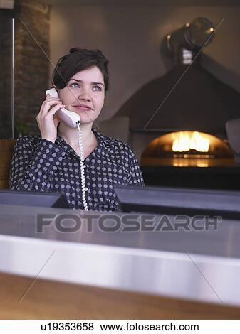 Hostess at her station in a restaurant View Large Photo Image Stock Photo - Hostess at her station in a restaurant. Fotosearch