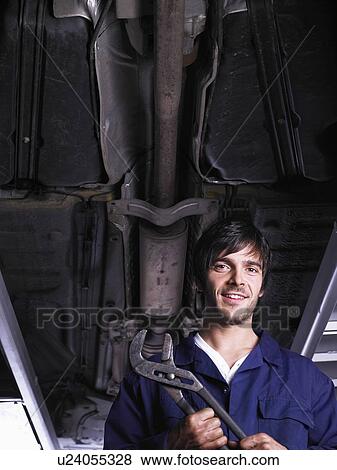 Stock Photo - Mechanic under a raised car. Fotosearch