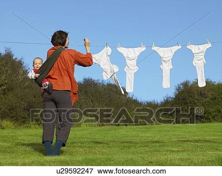 Stock Photo - Mother and baby hanging nappies outside. Fotosearch