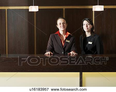 Stock Photo - Two hotel receptionists, smiling, portrait. Fotosearch