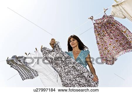 Picture - Woman hanging clothes. Fotosearch