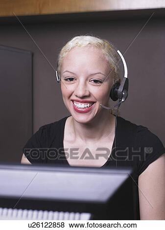 Stock Photo - Woman smiling on headset. Fotosearch