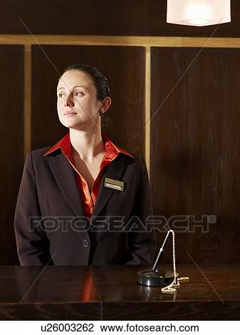 Stock Image - Young female hotel receptionist. Fotosearch