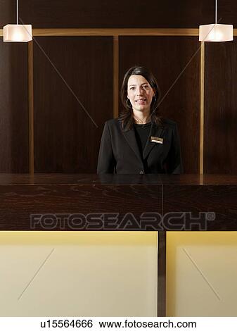 Stock Photograph - Young female hotel receptionist, smiling, portrait. Fotosearch