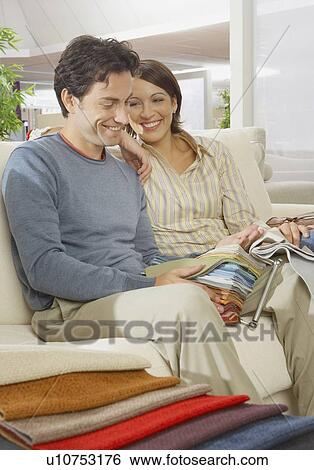 Couple sitting on sofa in furniture shop. View Large Photo Image Stock Photograph - Couple sitting on sofa in furniture shop.. Fotosearch