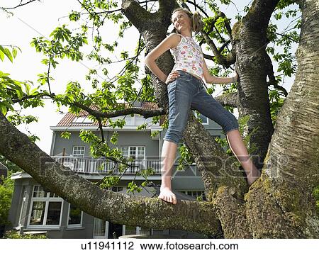 Girl in a tree, smiling View Large Photo Image Stock Image - Girl in a tree, smiling. Fotosearch