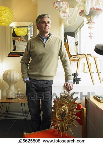 Mature man standing in furniture shop, smiling View Large Photo Image Stock Photo - Mature man standing in furniture shop, smiling. Fotosearch