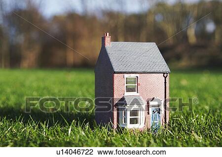 Stock Image - Model of house sits on lawn. Fotosearch