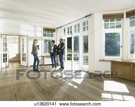Real estate agent showing house to a couple. View Large Photo Image Stock Image - Real estate agent showing house to a couple.. Fotosearch