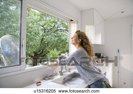 Woman at kitchen window View Large Photo Image Stock Photography - Woman at kitchen window. Fotosearch