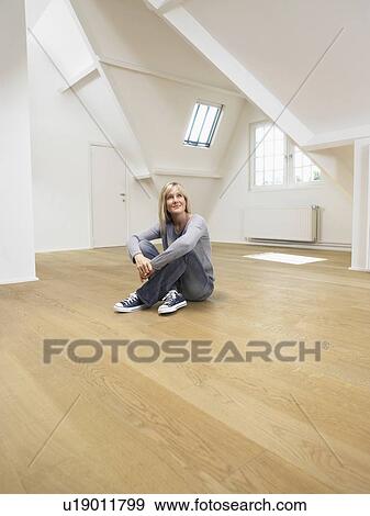 Woman seated on wooden floor of empty white loft. View Large Photo Image Stock Photo - Woman seated on wooden floor of empty white loft.. Fotosearch
