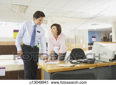Woman signing paperwork with salesman. View Large Photo Image Stock Image - Woman signing paperwork with salesman.. Fotosearch