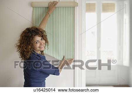 Picture - Woman trying wallpaper. Fotosearch