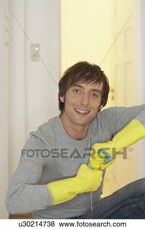 Young man wearing rubber gloves, smiling View Large Photo Image Stock Photo - Young man wearing rubber gloves, smiling. Fotosearch