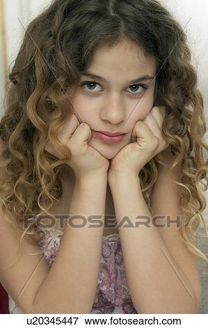 Stock Photo - Girl (9-11) leaning with hands on chin, portrait. Fotosearch