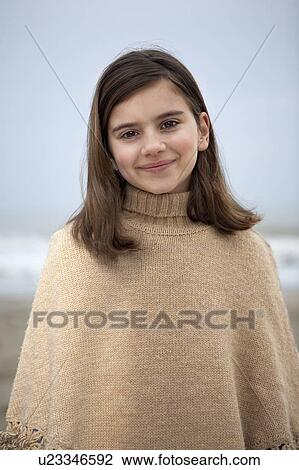Stock Image - Girl (9-11) on beach, smiling, portrait. Fotosearch