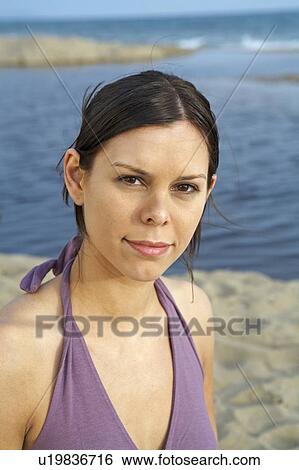 Young woman on beach portrait smiling into camera sea and sky in background. View Large Photo Image Stock Photograph - Young woman on beach portrait smiling into camera sea and sky in background.. Fotosearch