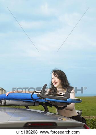 Female taking surfboard off car roof View Large Photo Image Stock Photo - Female taking surfboard off car roof. Fotosearch