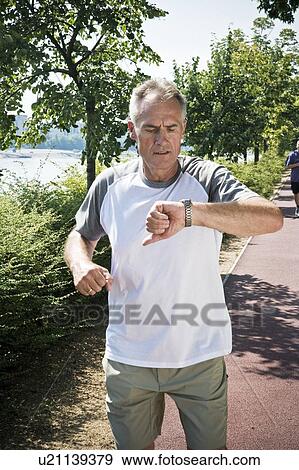 Jogger checking wristwatch View Large Photo Image Stock Photo - Jogger checking wristwatch. Fotosearch