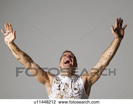 Joyous mud covered man with arms raised View Large Photo Image Stock Image - Joyous mud covered man with arms raised . Fotosearch