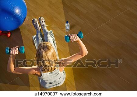 Mature woman lifting weights in a gym View Large Photo Image Stock Photo - Mature woman lifting weights in a gym. Fotosearch