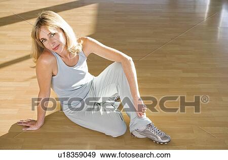 Stock Photo - Mature woman stretching in a gym. Fotosearch