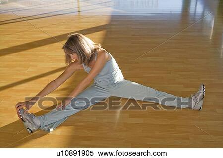 Stock Photography - Mature woman stretching in a gym. Fotosearch