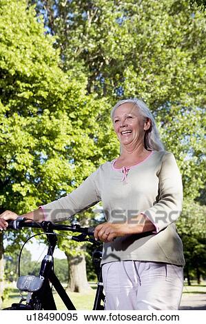 Stock Photography - Mature woman with bike. Fotosearch