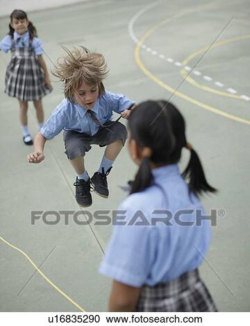 Stock Image - School boy skipping rope. Fotosearch