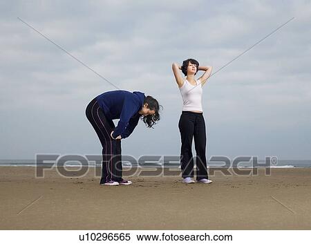 Stock Photography - Two young females resting on beach. Fotosearch