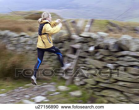 Woman jumping onto ladder. View Large Photo Image Stock Image - Woman jumping onto ladder.. Fotosearch