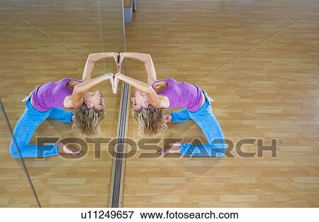 Stock Photo - Young woman stretching in a gym. Fotosearch
