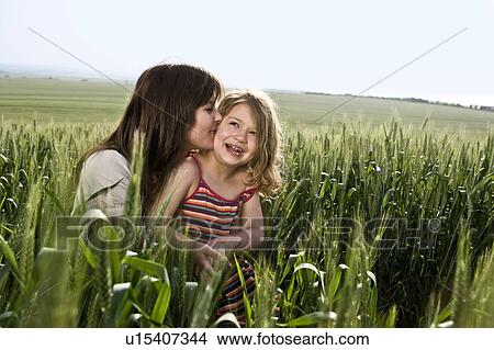 Picture - Mother kissing child in wheat field. Fotosearch