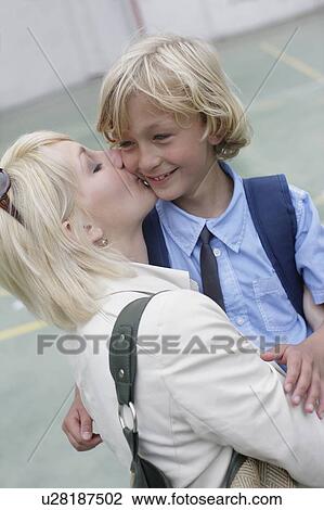 Stock Image - Mother kissing school boy. Fotosearch