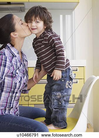 Stock Image - Mother kissing young boy. Fotosearch