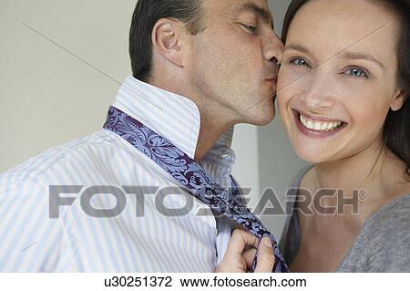 Woman knotting her man's tie View Large Photo Image Stock Image - Woman knotting her man's tie. Fotosearch