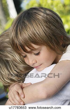 Stock Image - Young boy hugging mother. Fotosearch