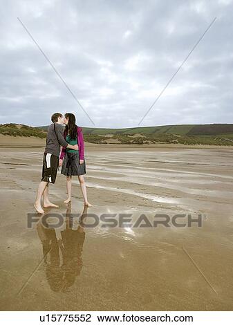 Young couple kissing on beach View Large Photo Image Stock Image - Young couple kissing on beach. Fotosearch