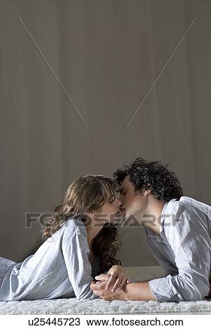 Young couple laying on floor, kissing View Large Photo Image Stock Image - Young couple laying on floor, kissing. Fotosearch
