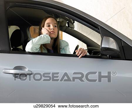 Picture - Girl (12-14) sitting in car, leaning on open window. Fotosearch