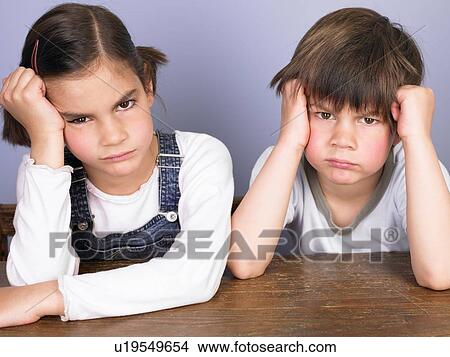 Picture - Girl and boy annoyed at their desk. Fotosearch