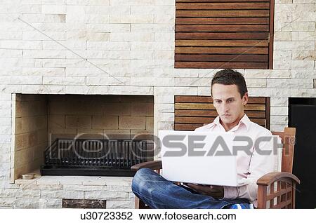 Man at laptop in courtyard View Large Photo Image Stock Image - Man at laptop in courtyard. Fotosearch