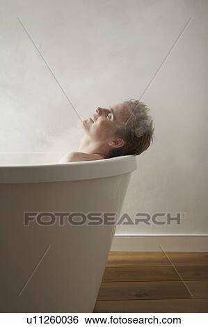 Stock Photograph - Mans head on edge of bath.. Fotosearch