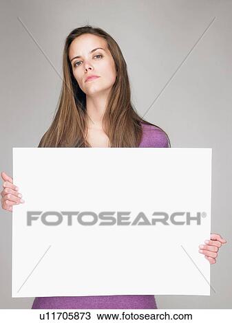 Stock Image - Woman carrying a notice, smiling. Fotosearch